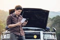 Man try to fix a car engine problem on a local road Chiang mai Thailand