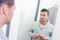 Man trying on clothes in mirror