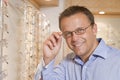Man trying on eyeglasses at optometrists