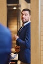 Man trying jacket on at mirror in clothing store Royalty Free Stock Photo