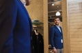 Man trying jacket on at mirror in clothing store Royalty Free Stock Photo