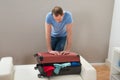 Man trying to close suitcase