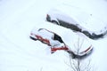 Man trying to free his car from snowy captivity. Parked cars covered with snow