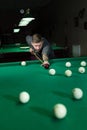 Man trying to hit the ball in billiard. Billiard room on the background. Royalty Free Stock Photo