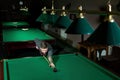 Man trying to hit the ball in billiard. Billiard room on the background Royalty Free Stock Photo