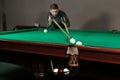 Man trying to hit the ball in billiard. Billiard room on the background Royalty Free Stock Photo