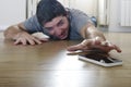 Man trying to reach mobile phone creeping on the ground in smart phone and internet addiction concept