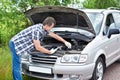 Man trying to repair broken car