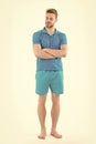 Man in tshirt and shorts barefoot isolated on white background. Bearded man with eyes closed in blue clothes. Macho in