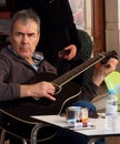 Man Tuning Guitar In Lagos Portugal