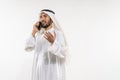 man in a turban is calling using a mobile phone while smiling