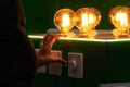 A man turns on round energy-efficient light bulbs in a glass bulb with warm light