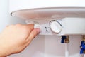 Man turns on the switch on control panel of home electric water heater boiler Royalty Free Stock Photo