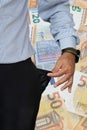 Man turns up his trouser pocket and Euro money notes background Royalty Free Stock Photo