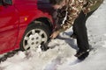 The man turns up shovel wheel of a car with snow drifts. Royalty Free Stock Photo