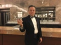 A man in a tux holding an old fashioned cigarette at a bar Royalty Free Stock Photo