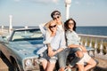 Man and two beautiful women standing together near vintage car Royalty Free Stock Photo