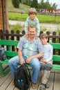 Man and two boys sit on bench Royalty Free Stock Photo