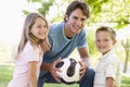 Man and two children outdoors holding volley