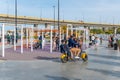 A man with two children rides an electric scooter