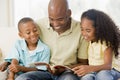 Man and two children sitting in living room Royalty Free Stock Photo