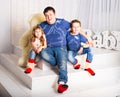 Man and two children sitting in living room smiling Royalty Free Stock Photo