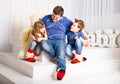 Man and two children sitting in living room smiling Royalty Free Stock Photo