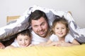 Man with two young children on bed smiling Royalty Free Stock Photo