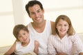 Man with two young children sitting in bed smiling Royalty Free Stock Photo