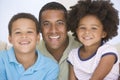 Man and two young children sitting in living room Royalty Free Stock Photo