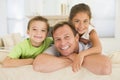 Man and two young children sitting in living room Royalty Free Stock Photo