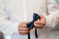 A Man Tying a Classic Navy Blue Bow Tie Before an Event Royalty Free Stock Photo