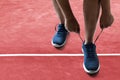 Man tying running shoes on racing track