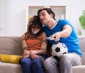 Man tying up his wife to watch sports football Royalty Free Stock Photo