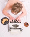 Man with typewriter and coffee lay bed. Author guy tousled hair busy write chapter deadline coming top view. Man Royalty Free Stock Photo