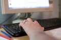 Man typing on computer keyboard with his left hand, remote work at home,