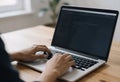 Man Typing on Laptop with Code on Screen in Natural Light Royalty Free Stock Photo