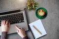 Man typing on laptop computer with white blank screen a cement wall background office desk table. Royalty Free Stock Photo