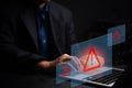Man typing on laptop with floating red warning icons. Represents cybersecurity threats, data protection, and digital risk