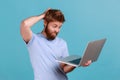 Man typing on laptop, having new idea and planning own strategy, holding one hand on the head. Royalty Free Stock Photo