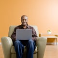 Man typing on laptop in livingroom Royalty Free Stock Photo