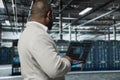 Man typing on laptop in server hub, monitoring energy consumption using AI Royalty Free Stock Photo