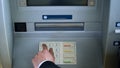 Man typing pin code on ATM keyboard to withdraw money from bank account, access