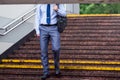 A man with an umbrella down the subway on the granite stairs