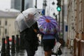 A man with an umbrella is hiding from strong winds and rain Royalty Free Stock Photo