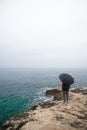man with umbrella looking at stormy sea Royalty Free Stock Photo