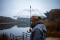 Man with umbrella standing on lake pier in rainy day Royalty Free Stock Photo