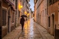 A man with an umbrella on the street in Porec town.