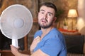 Man during unbearable heatwave using electric fan Royalty Free Stock Photo