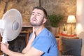 Man during unbearable heatwave using electric fan Royalty Free Stock Photo